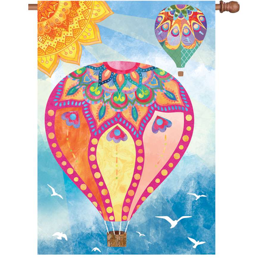 28 in. Hot Air Balloons flag with colorful mandala design fluttering on a flagpole, enhancing an outdoor garden setting.