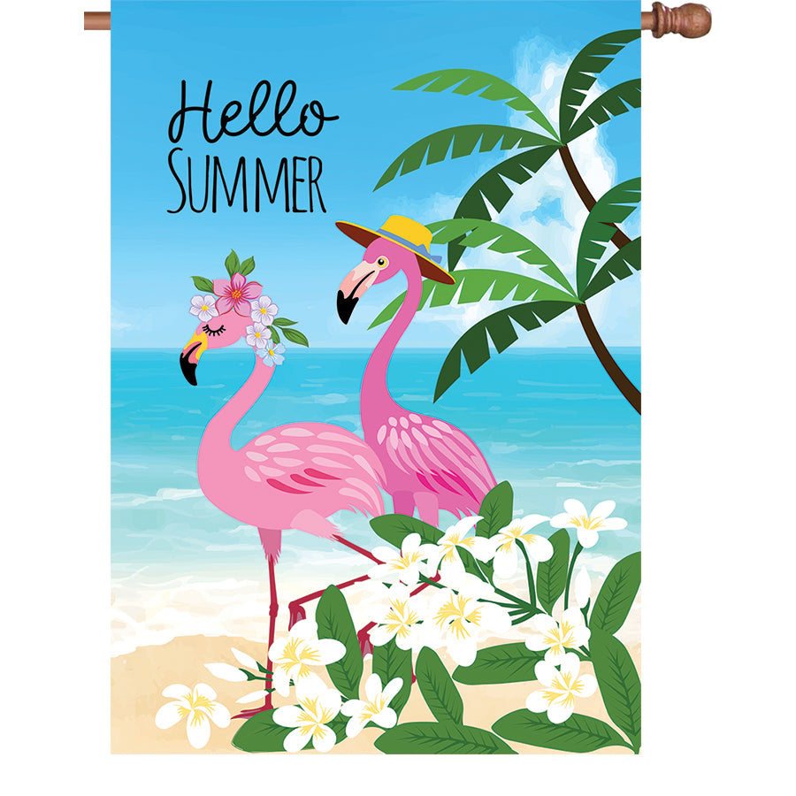 28 in. Summer Flamingo garden flag featuring two pink flamingos on a beach background, displayed outdoors to celebrate the summer season.
