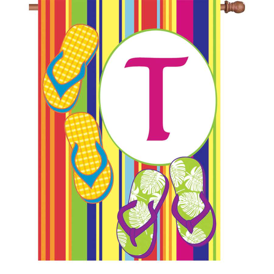 28 in. Summer Monogram Flag - T, showcasing a vibrant monogram design, displayed on a flagpole in a well-kept garden setting.