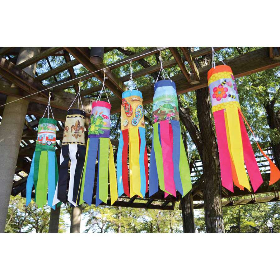 Vibrant 28 in. Happy Camper windsock featuring playful camping icons displayed outdoors, fluttering in the wind.