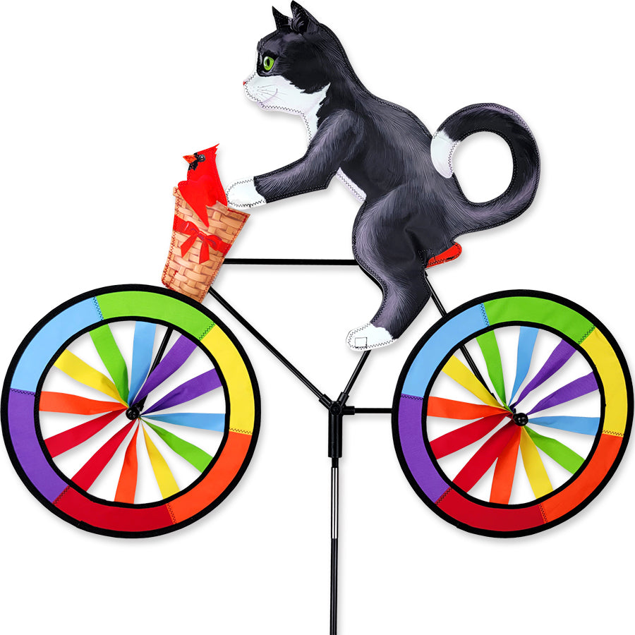 30 in. Bike Spinner featuring a colorful Tuxedo Cat design, elegantly spinning on a bicycle in an outdoor setting.