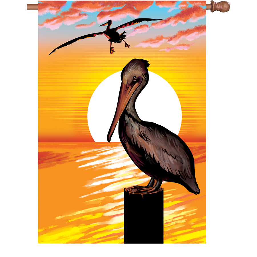 36 in. Elite Oversized House Flag with a colorful pelican silhouette, fluttering gently on a standard flag pole in a garden setting.