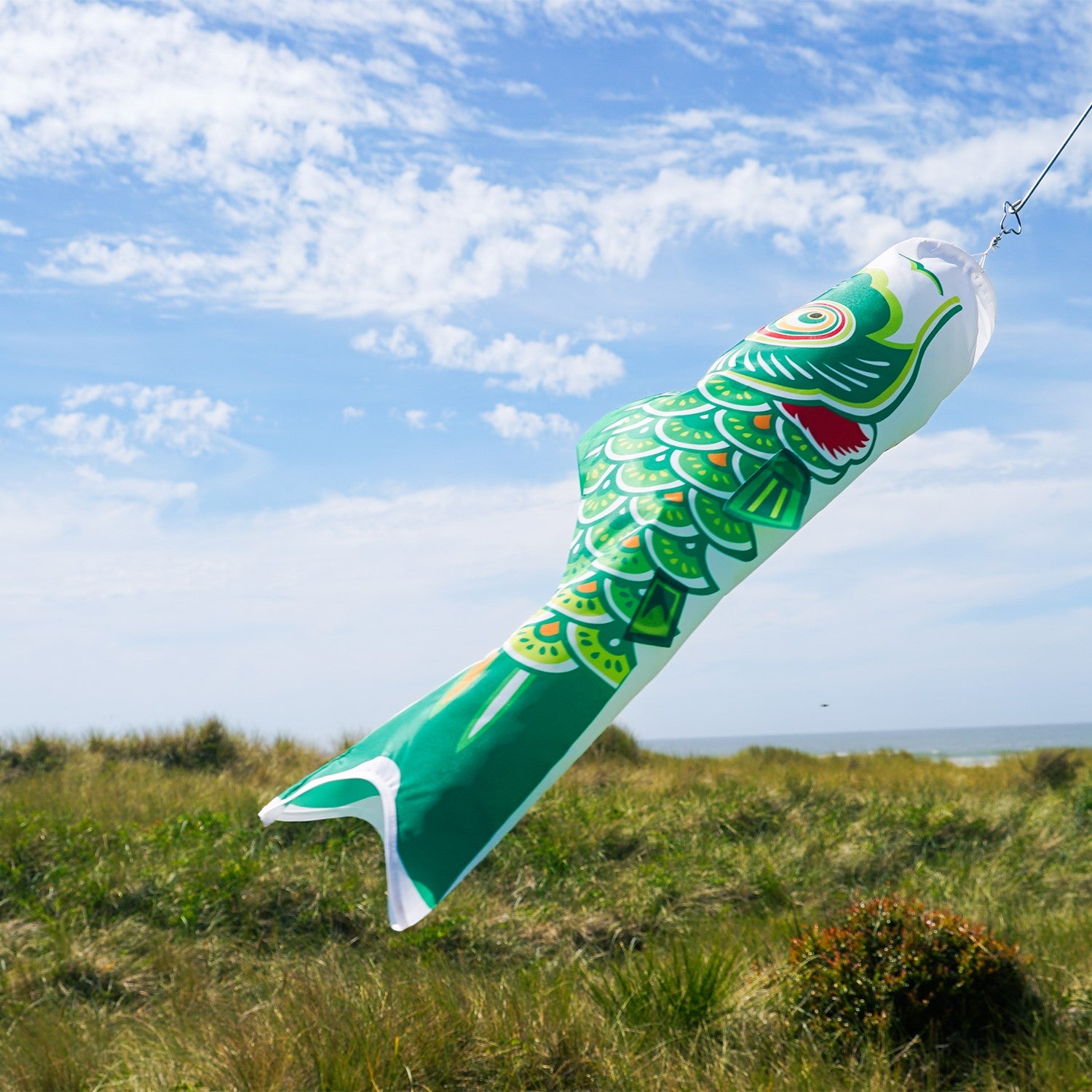 36-inch Green Koi windsock hanging outdoors, showing vibrant colors and intricate details, perfect for garden decoration.
