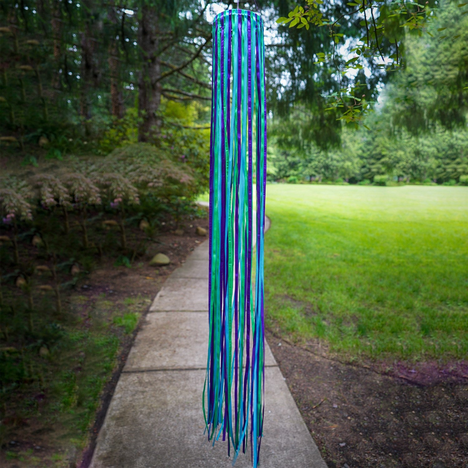 39-inch Ocean Ribbon Windsock featuring vibrant blue, green, and purple satin ribbons elegantly flowing around a PVC hoop in motion outdoors.