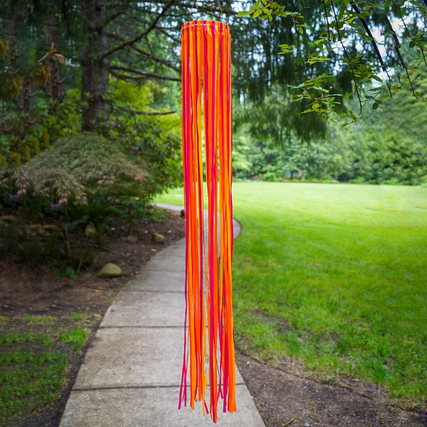 39-inch Sunset Ribbon Windsock featuring vibrant satin ribbons in fuchsia, orange, and yellow displayed outdoors, swaying gently in the wind.