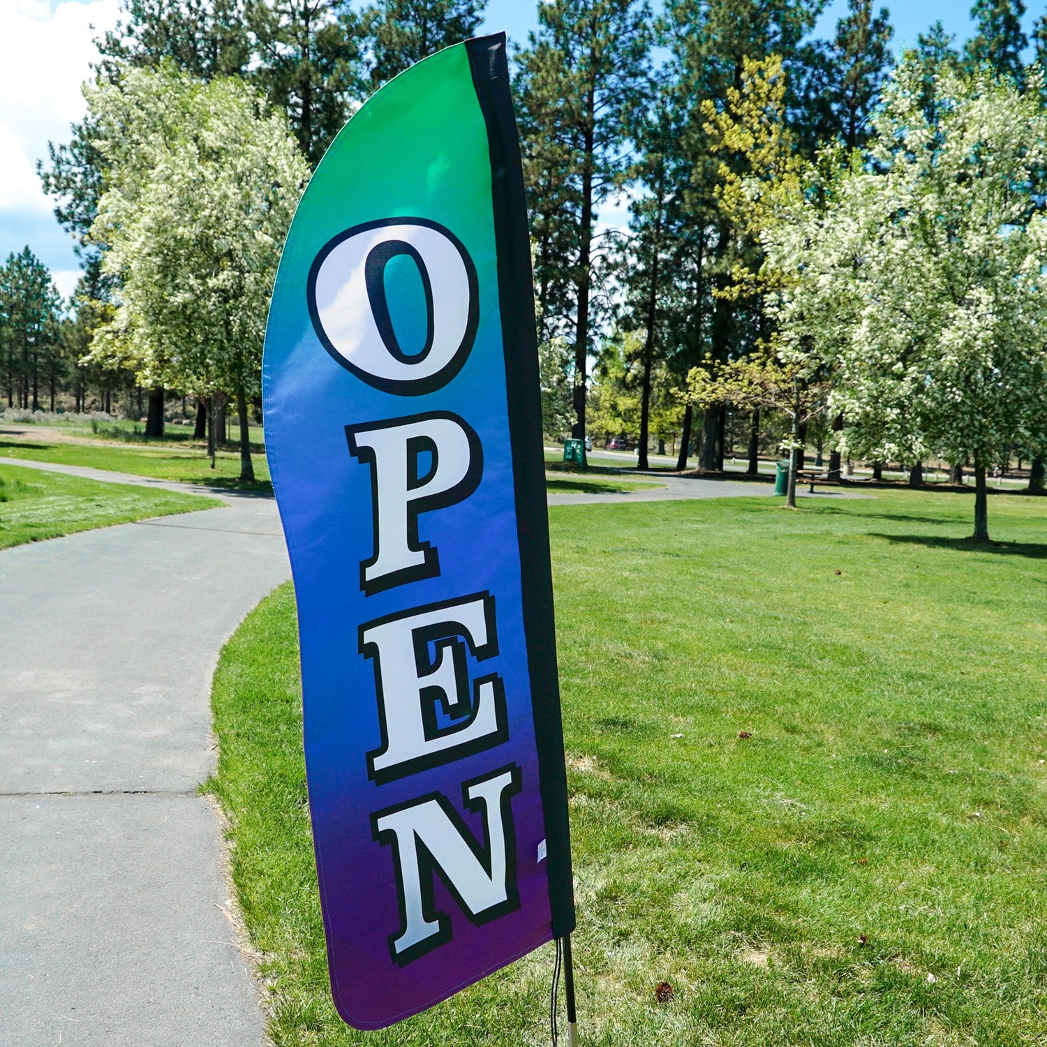 4-foot Heavy Duty Open Gradient Double Sided Feather Banner displayed outdoors, featuring vibrant rainbow colors and 'open' signage in an event setting.