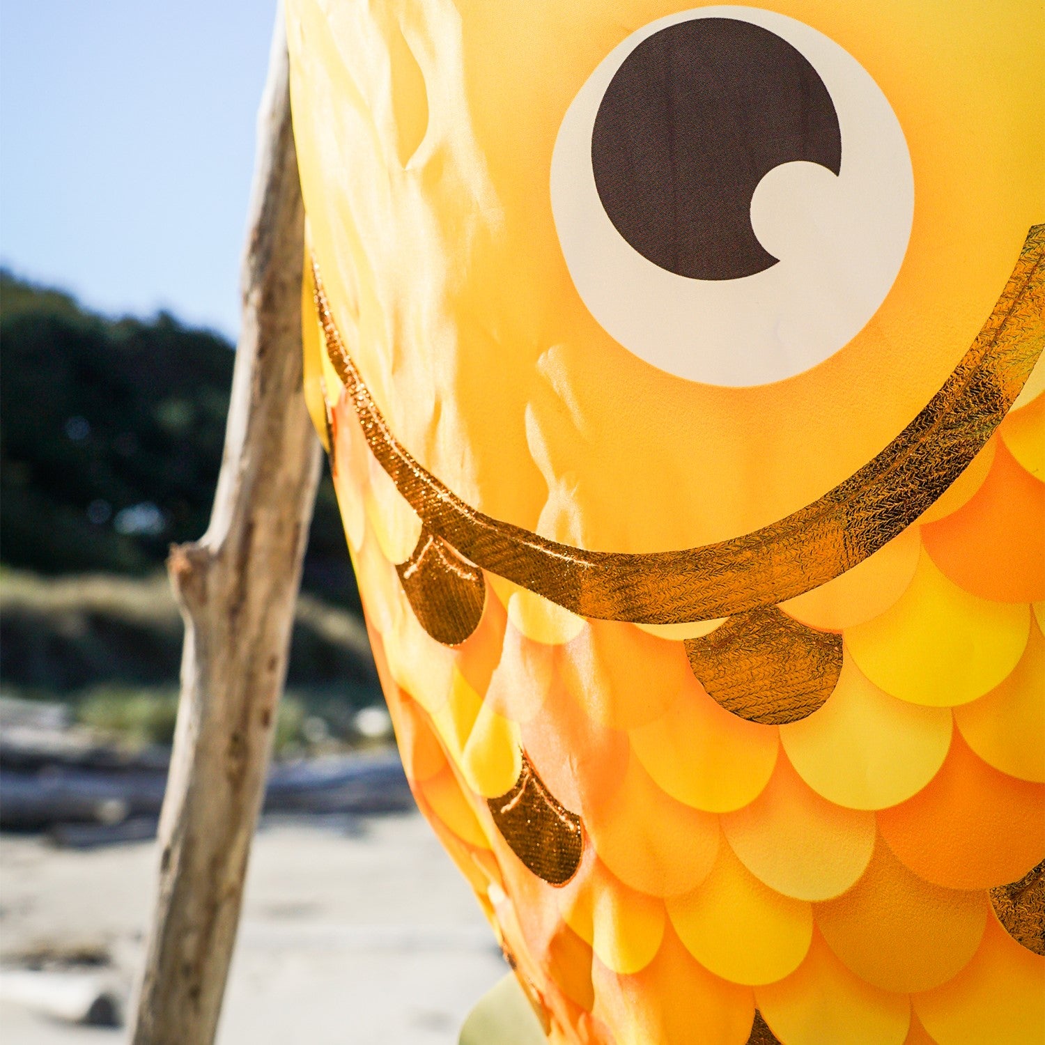 40-inch Gold Shimmer Damsel Fish Windsock with shiny scales and colorful tail, gracefully swaying in the breeze in a garden setting.