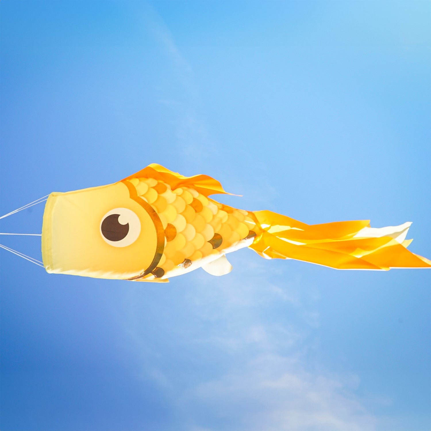 40-inch Gold Shimmer Damsel Fish Windsock with shiny scales and colorful tail, gracefully swaying in the breeze in a garden setting.