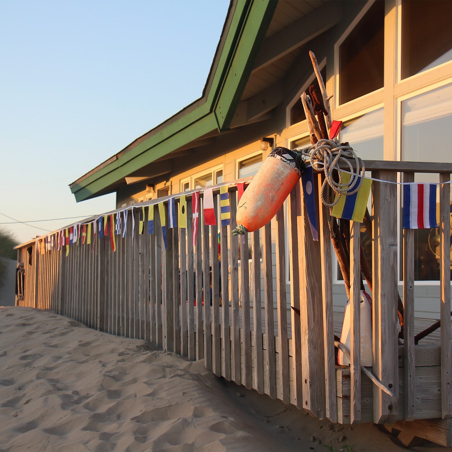 40 Piece Maritime Signal Flags on String decorated across a wooden terrace, featuring various colors and nautical designs that represent maritime communication.