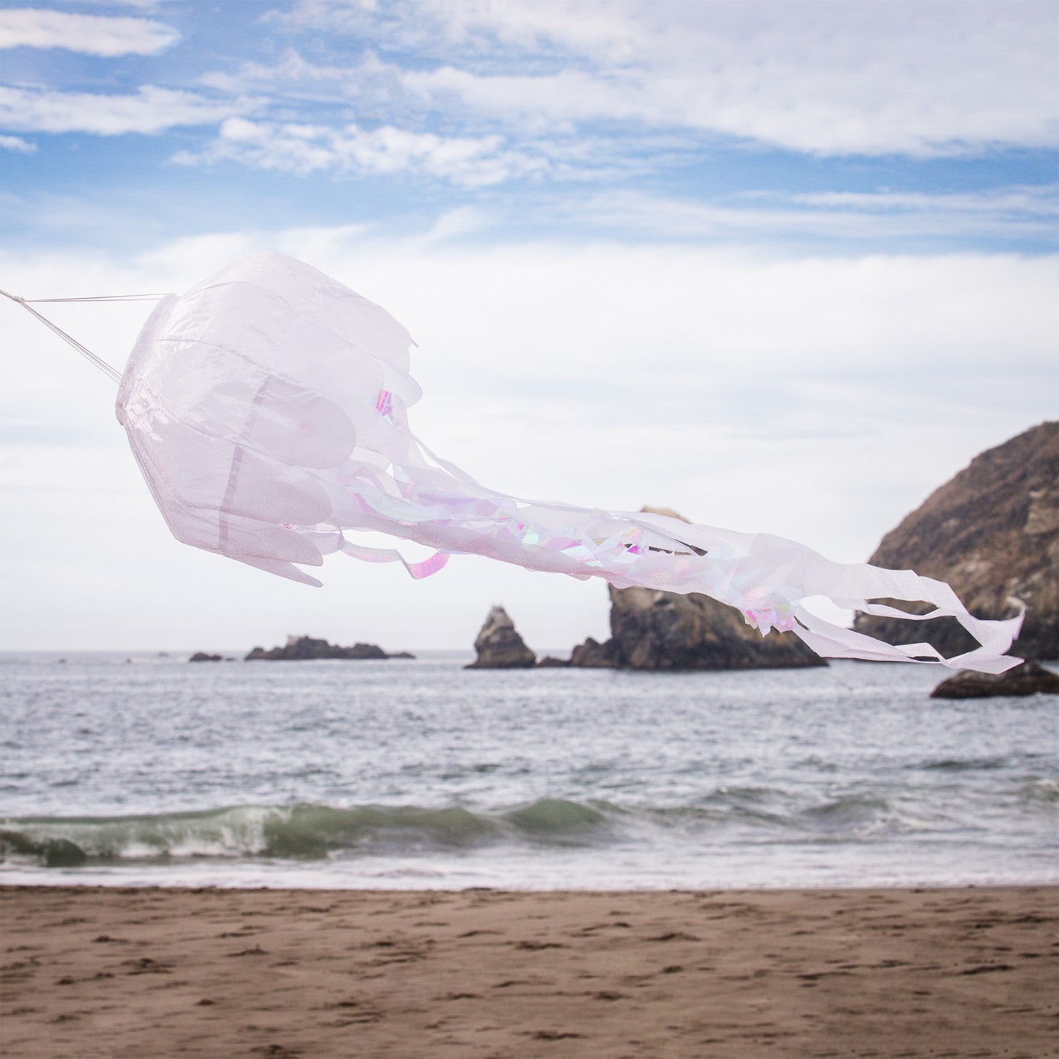 A 40-inch White Iridescent Jellyfish 3D Windsock swaying in the wind, highlighting its shimmering fabric and lifelike tentacles.