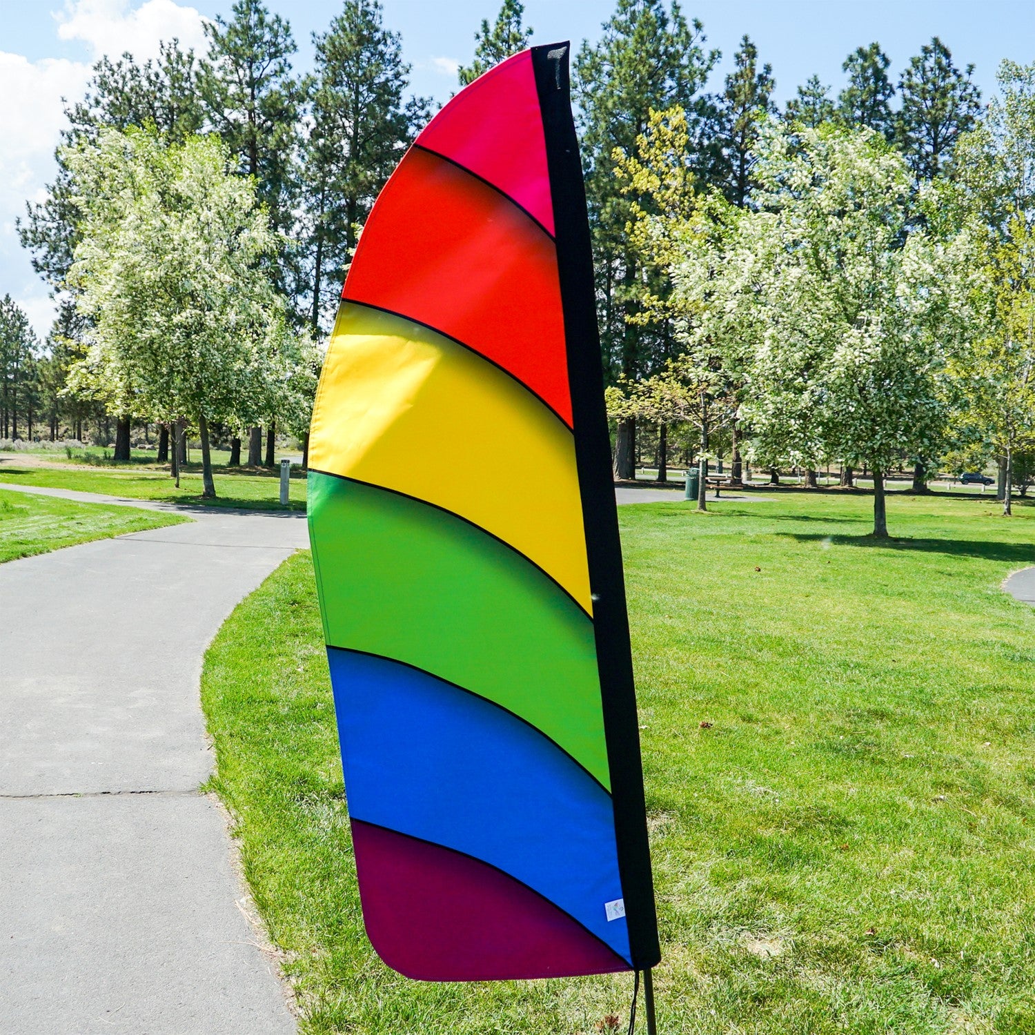 4' Heavy Duty Rainbow Double Sided Feather Banner displaying a vibrant rainbow gradient design outdoors, perfect for business promotions.