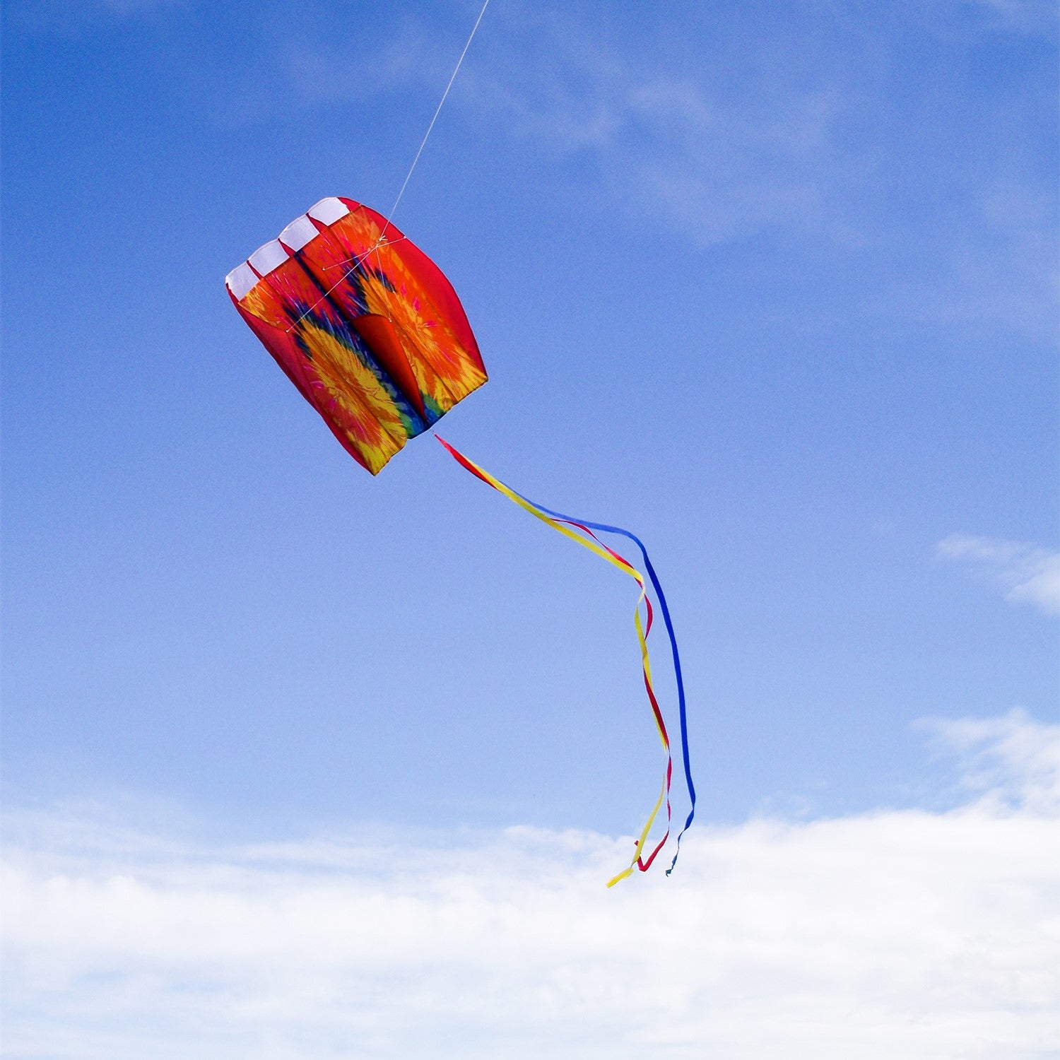 5.0 Tie Dye Red Air Foil Kite soaring in a bright blue sky, showcasing its vibrant colors and aerodynamic structure.