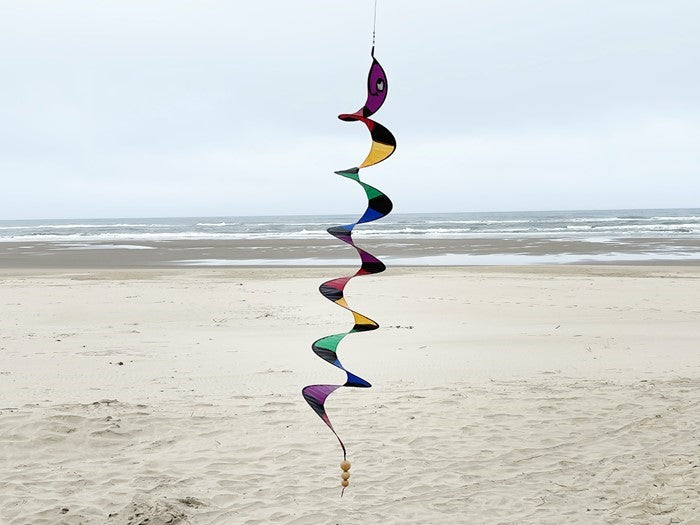 57" Rattlesnake Curlie wind fairy hanging outdoors, displaying vibrant rattlesnake design that spins gently in the breeze.