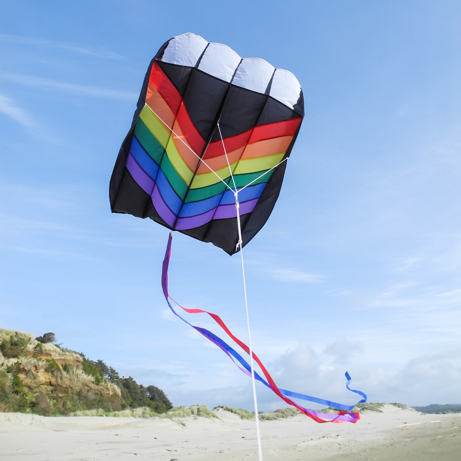 7.5 Rainbow Air Foil kite in flight, showcasing vibrant colors and aerodynamic design against a clear blue sky.