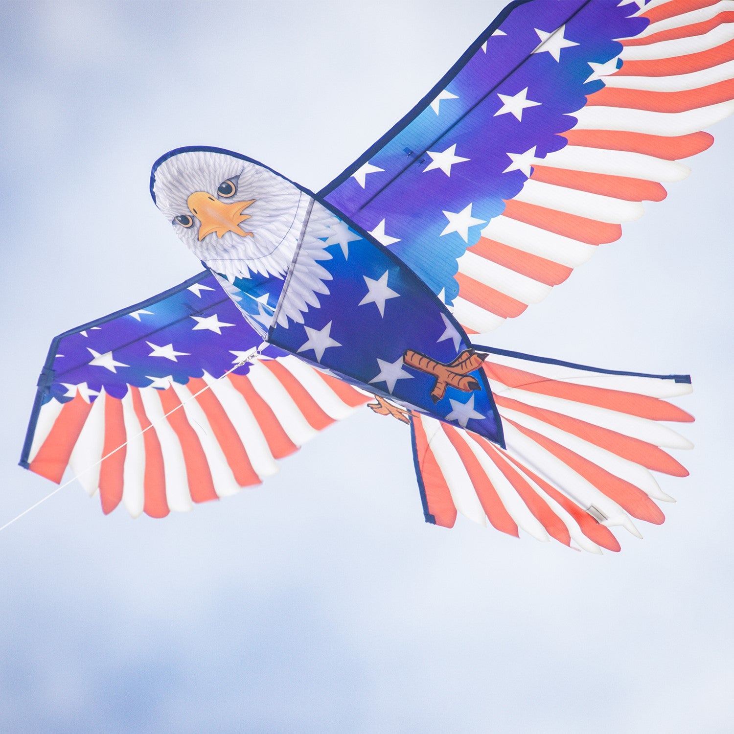 70-inch Patriotic Bald Eagle Kite soaring in the sky, featuring a majestic bald eagle design and American flag patterns against a blue backdrop.