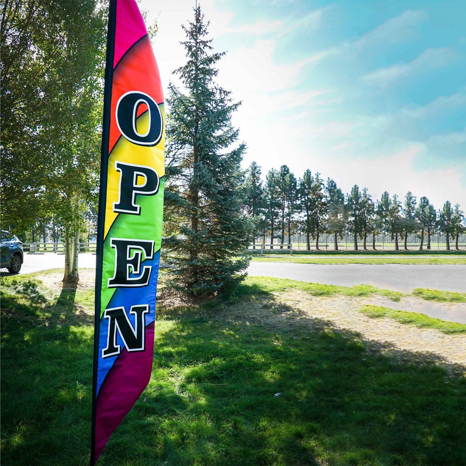 8' Heavy Duty Open Double-Sided Feather Banner displaying a colorful rainbow design outdoors, attracting attention to a storefront.