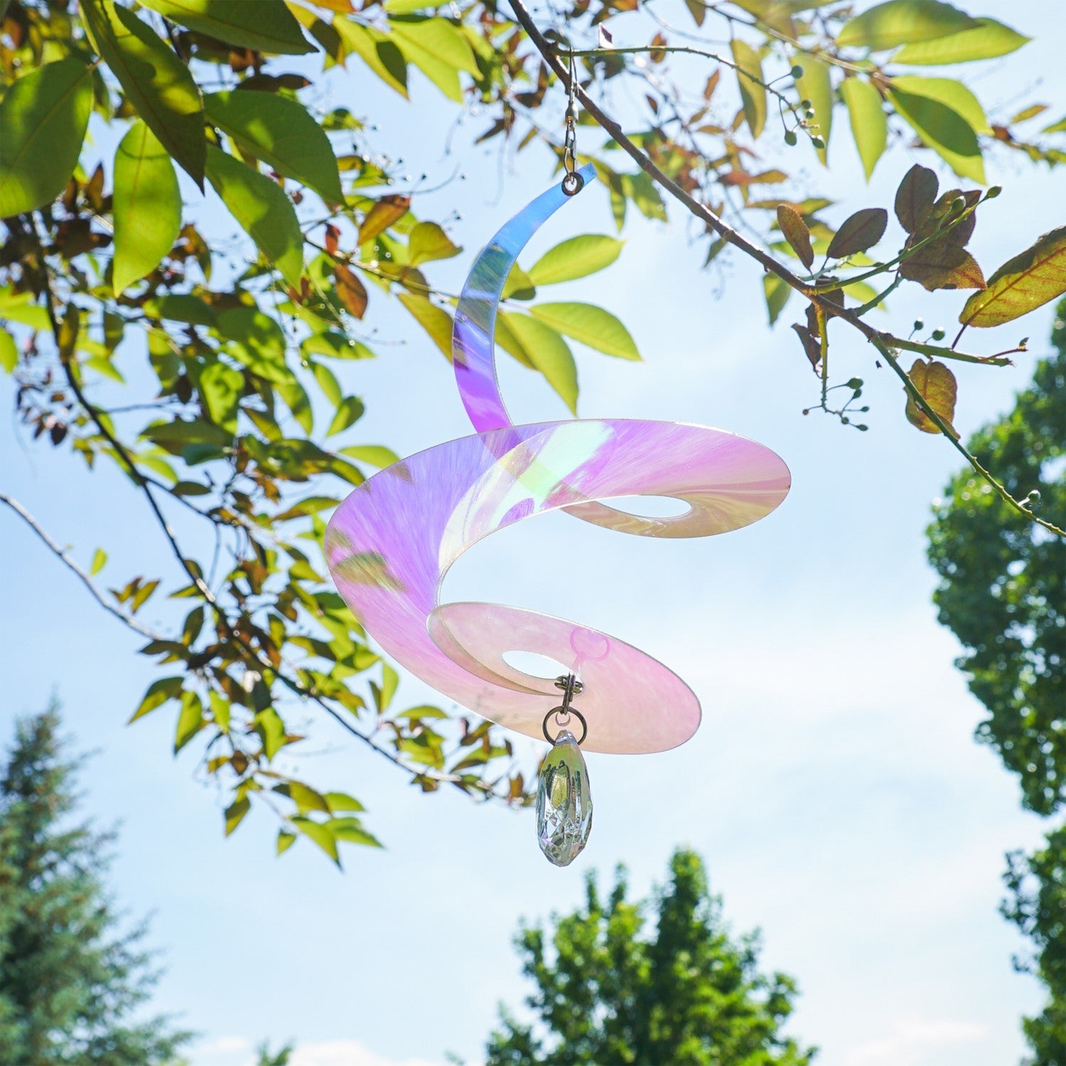 8-inch iridescent tear drop curlie with crystal spinner, shimmering in sunlight, hanging gracefully in an outdoor setting.