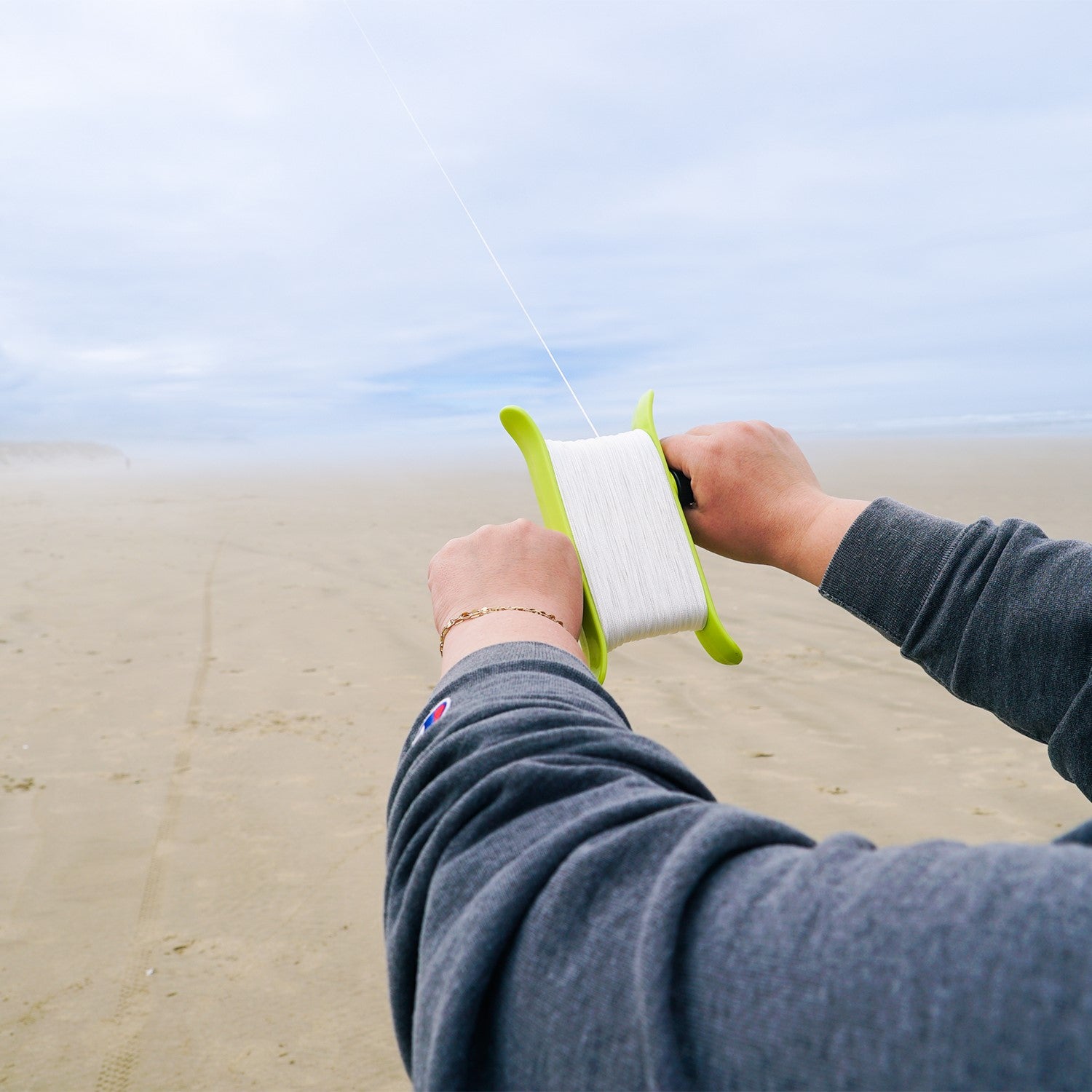 Green 80lb x 500' Braided Breezy WinderTM, featuring strong braided kite line, designed for effortless kite management and outdoor fun.