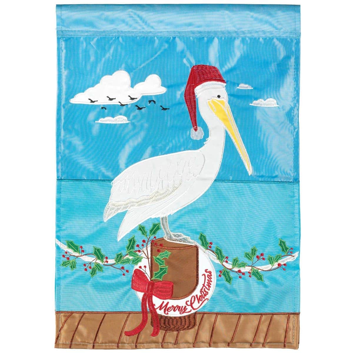 13x18 Christmas Pelican garden flag displayed on a metal garden pole, pelican wearing a Santa hat and scarf with holly and coastal accents, double applique layers and embroidered details visible.
