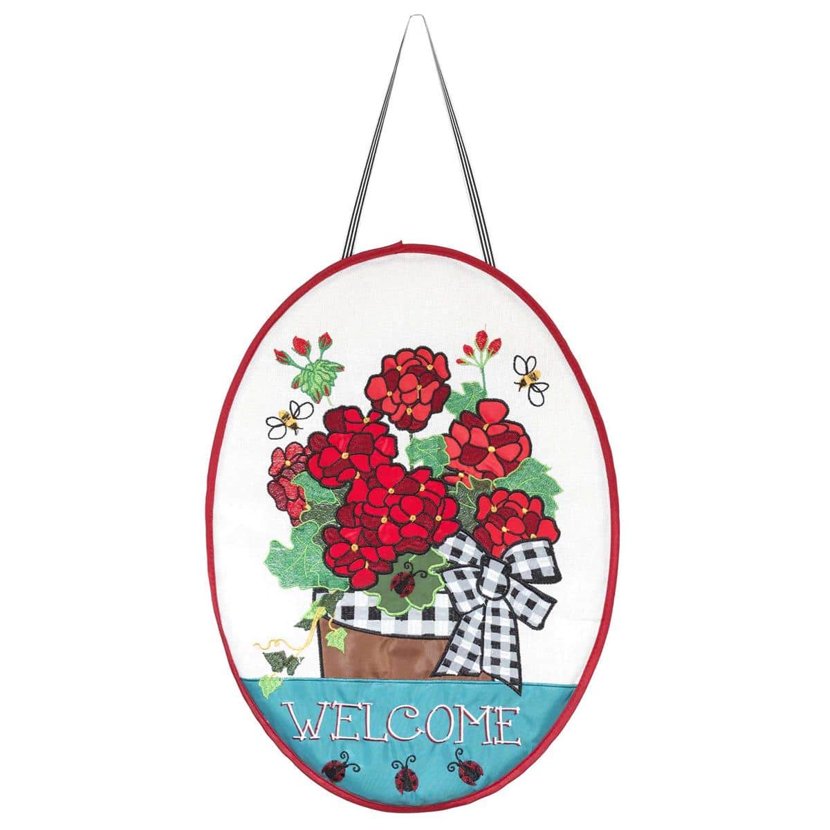 Burlap door banner with bold red geraniums and Welcome text hanging on a front door, rustic floral entryway decoration for home or porch