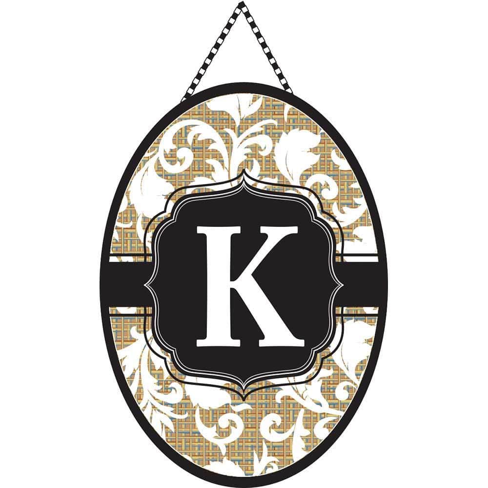 Front door banner showing a large scripted letter K monogram centered on a neutral background, hanging over a porch entry and framed by seasonal planters.