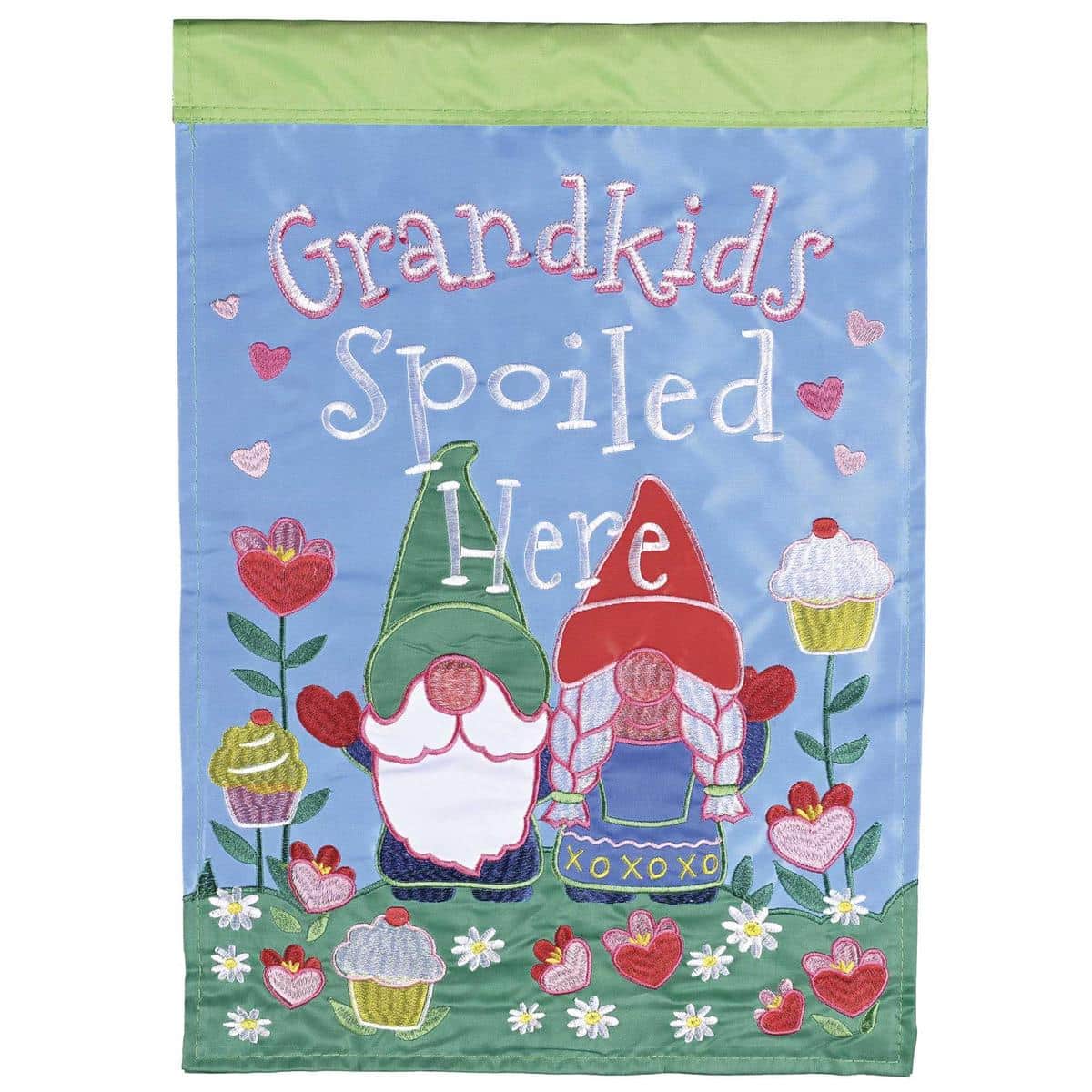 13x18 Grandkids Spoiled Here garden flag with layered double applique lettering and decorative motifs displayed on a garden pole in a colorful flower bed reflecting family-friendly outdoor decor.