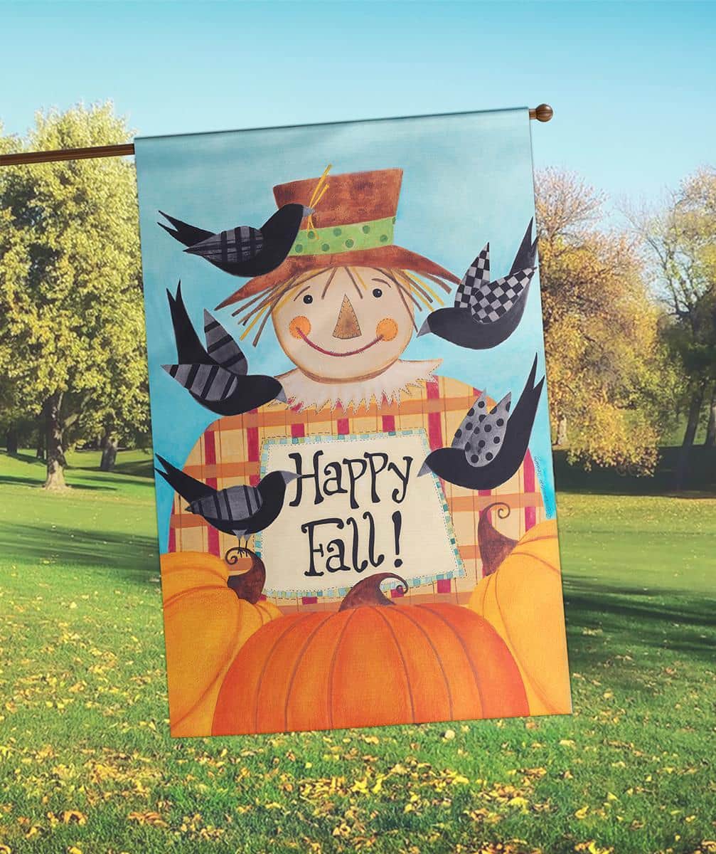 30x44 Happy Fall Scarecrow printed banner flag showing smiling scarecrow, pumpkins, fall leaves, and 'Happy Fall' greeting hanging on a front porch railing for seasonal decor.