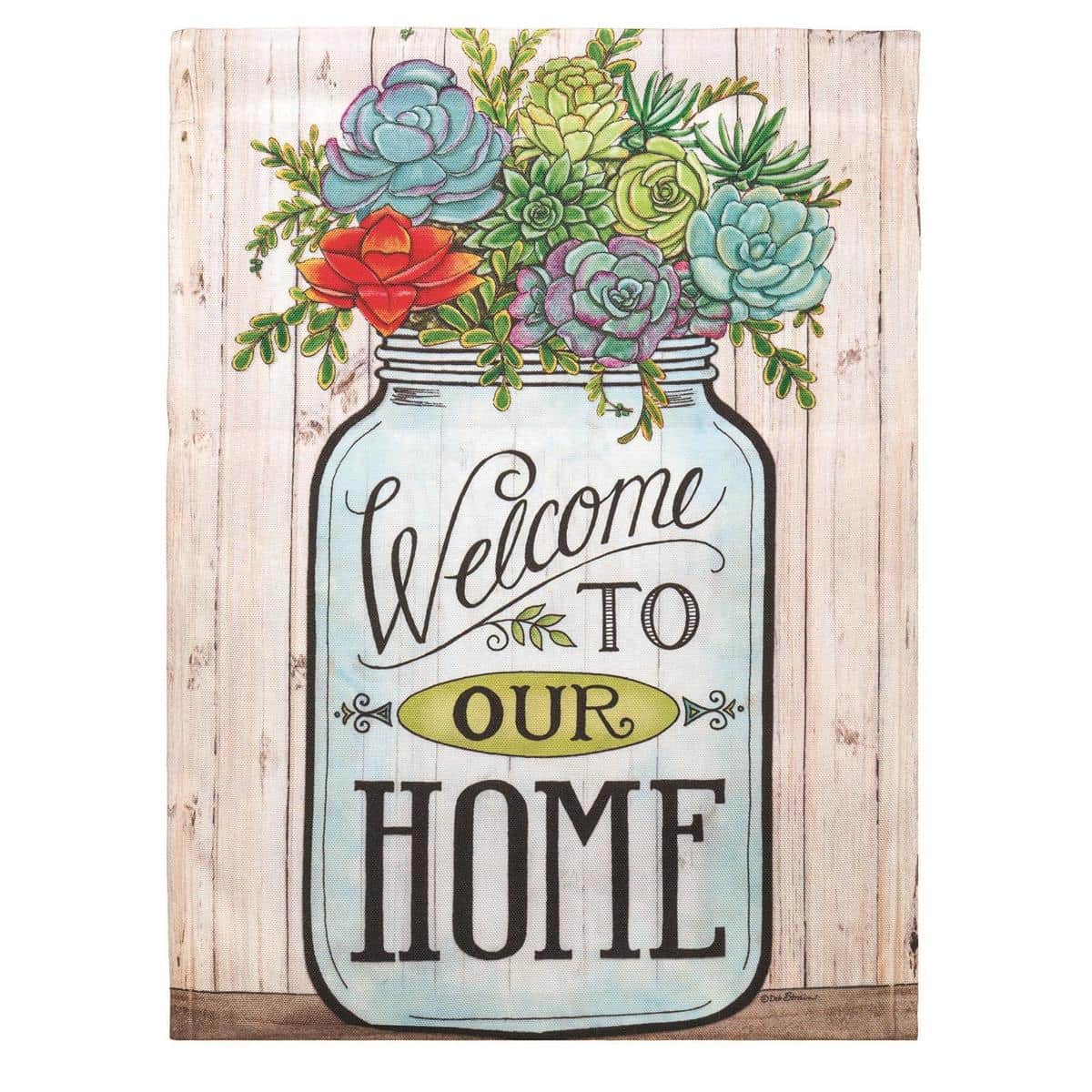 13x18 Mason Jar Welcome garden flag with printed floral bouquet inside a rustic jar and clear Welcome text, shown hanging on a black metal garden flag stand at a brick porch.