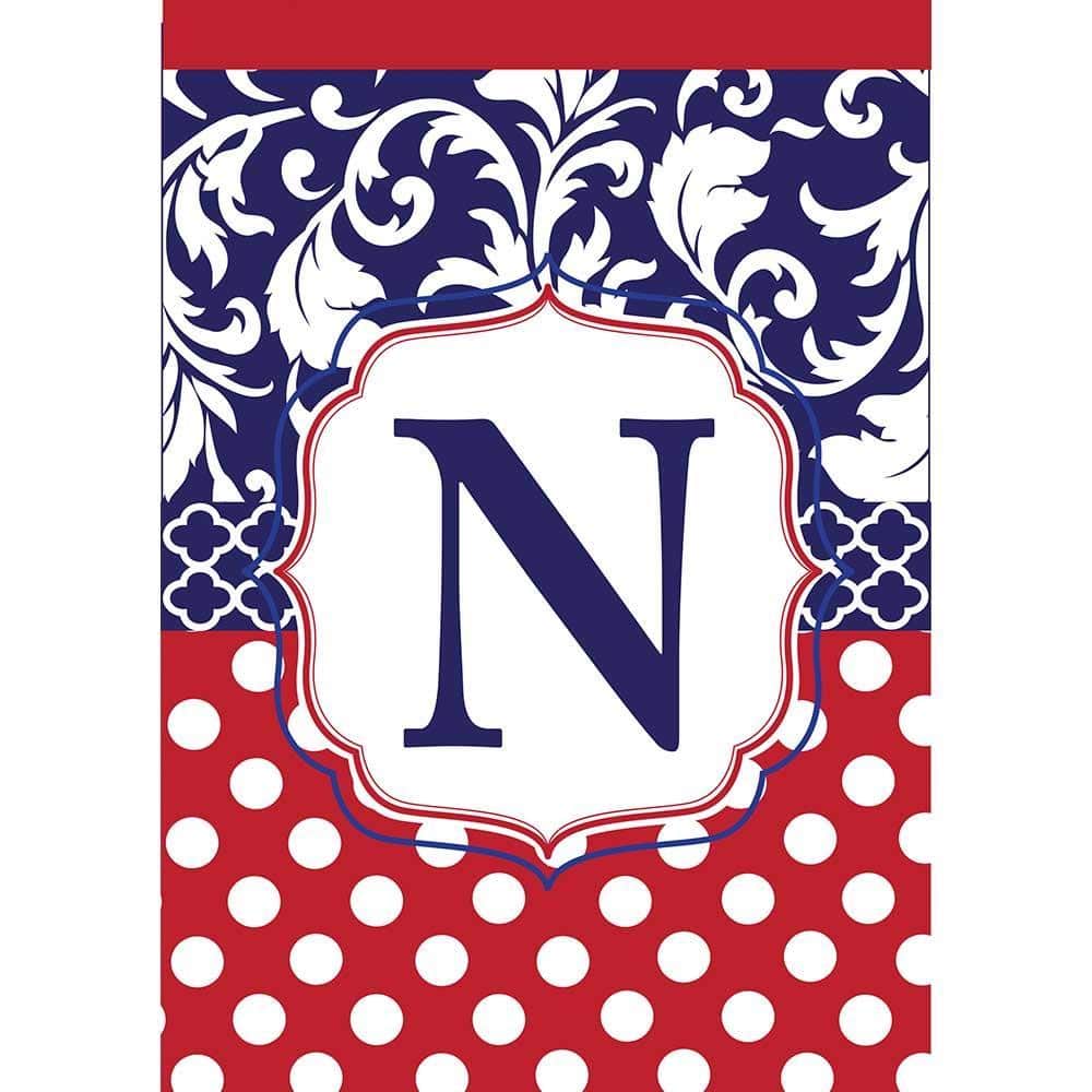 Red, white, and blue double applique garden flag with monogram N, 13x18 size, two-sided design shown on a standard stand in a landscaped yard.