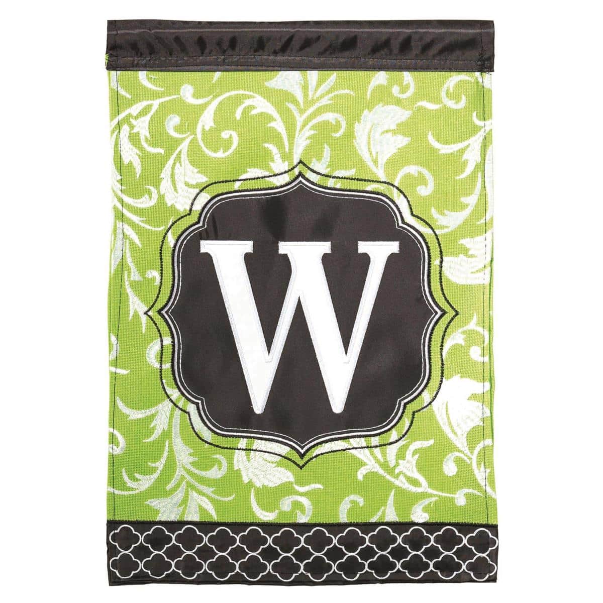 Green and black Monogram-W 13x18 double applique garden flag displayed on a metal garden flag stand showing the raised monogram letter, layered fabric texture, and reinforced sleeve for standard poles.