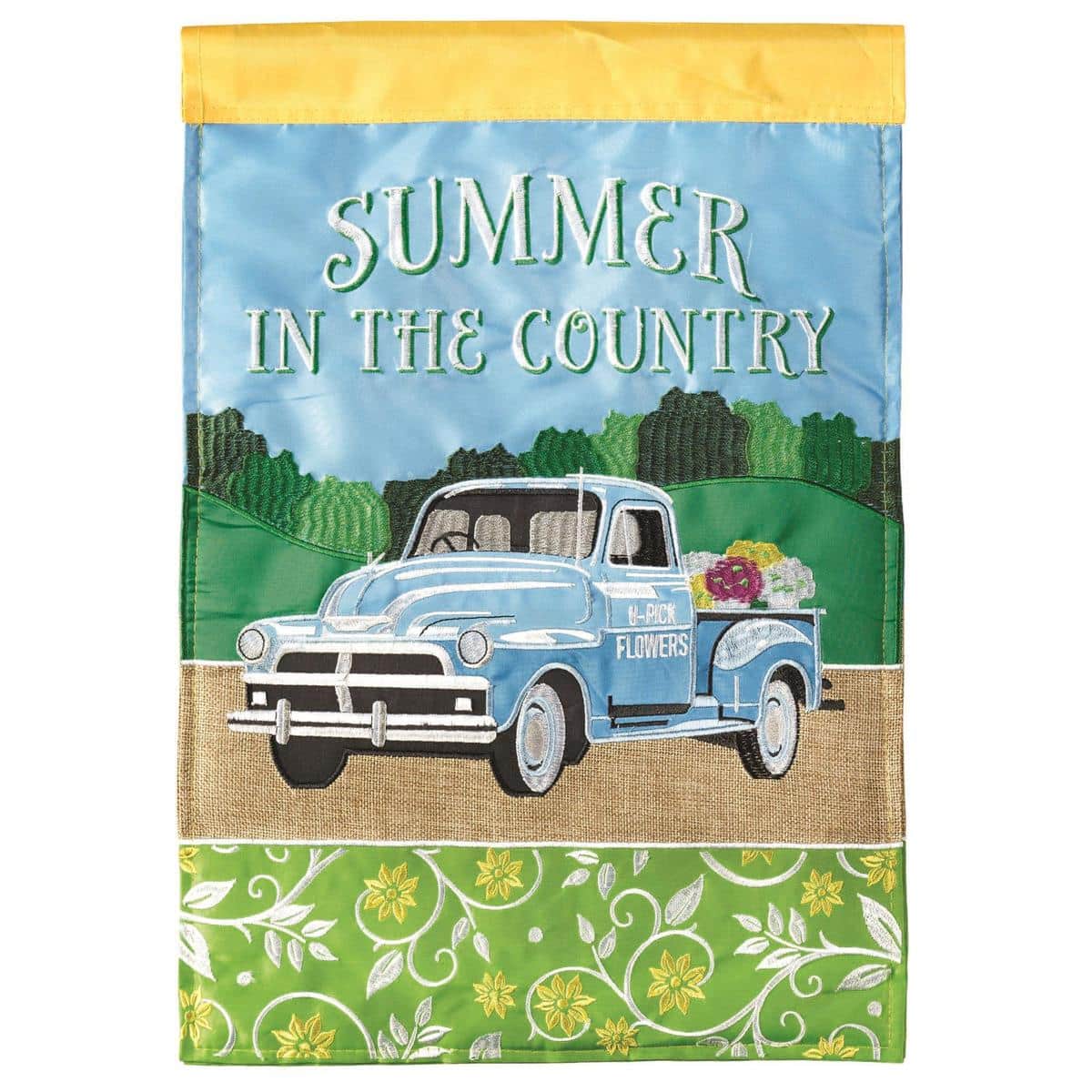 13x18 burlap garden flag showing a vintage flower-filled pickup truck in layered double applique with vibrant summer blooms and rustic texture, displayed on a lawn flag pole.