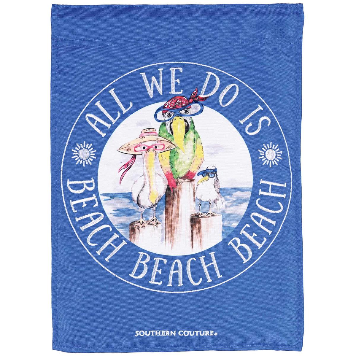 All We Do Beach Beach Beach garden flag in vibrant colors, featuring detailed fabric appliques and embroidery, displayed in a garden setting.