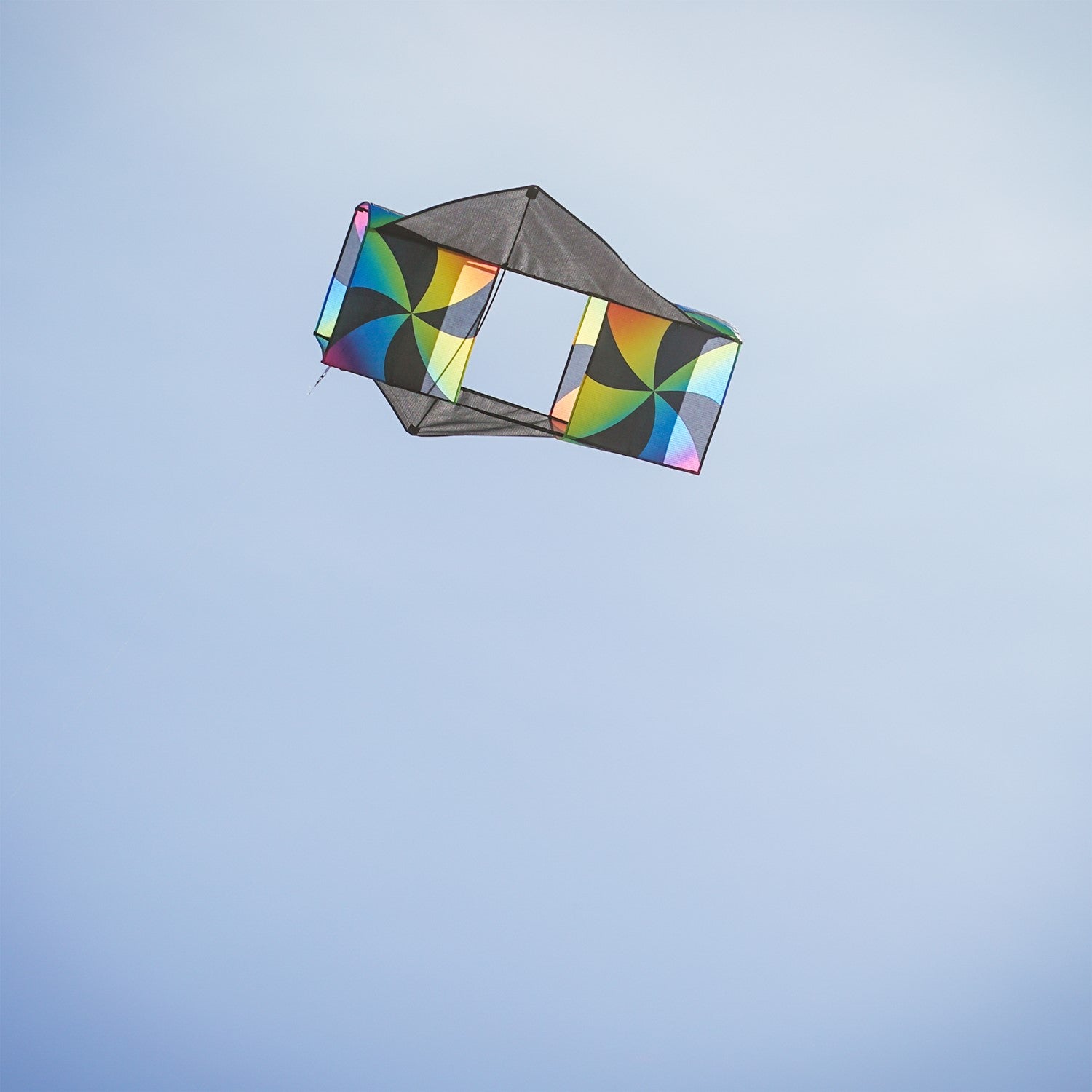 Aurora Winged Double Box Kite soaring high with its vibrant wings against a clear blue sky, showcasing its colorful design during flight.
