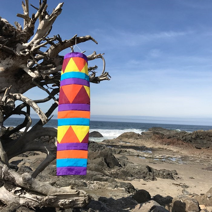 Aztec 60-inch Cone Windsock in vibrant jeweled colors, featuring applique and printed details, displayed in a garden setting.