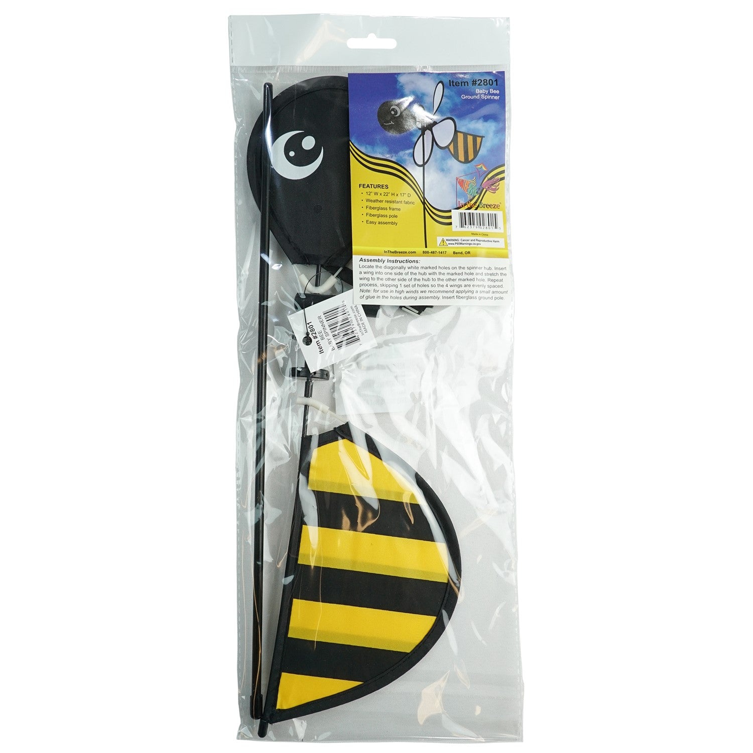 Bee Baby Spinner with colorful 12-inch wheel and bee design, elegantly spinning in a sunny garden setting on a fiberglass pole.