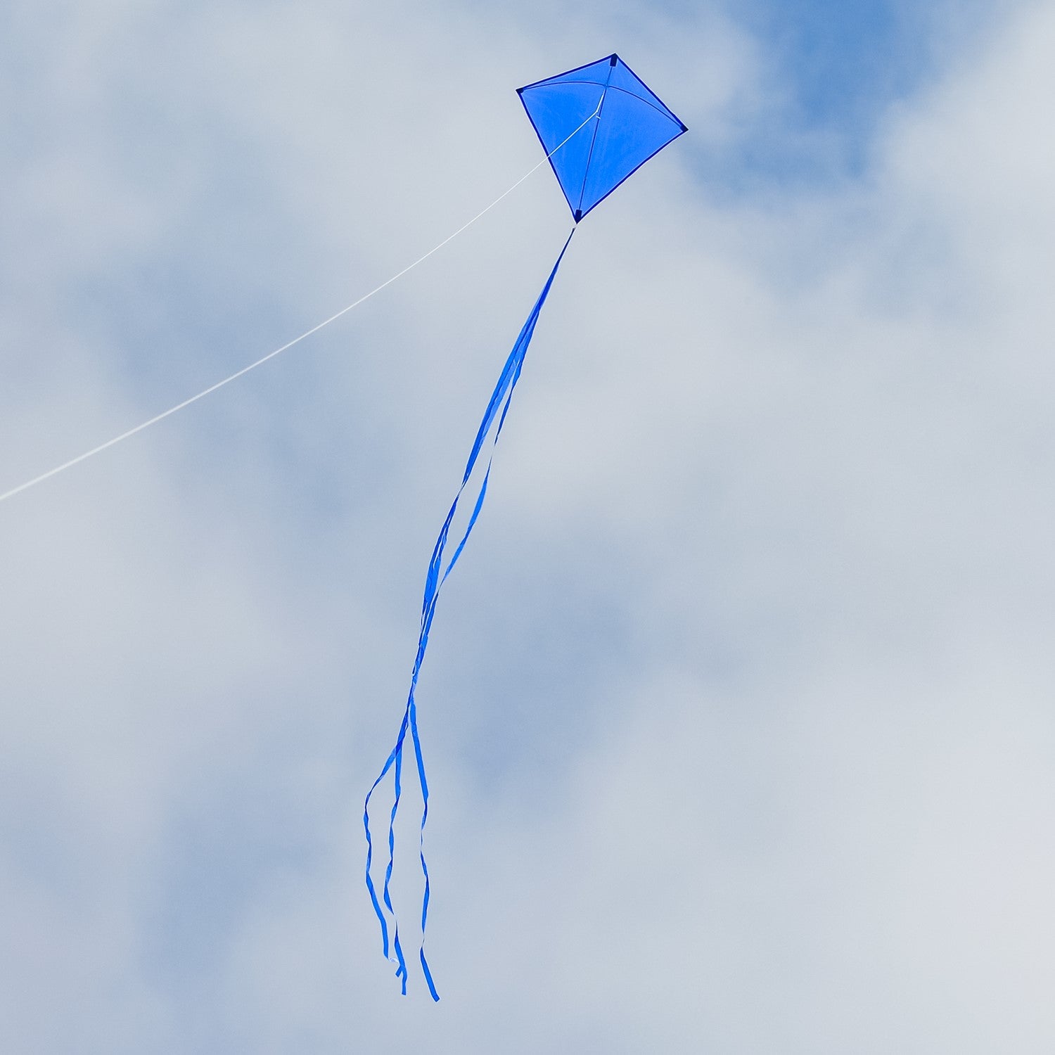 Blue Colorfly 30-inch Diamond Kite with three tails soaring against a clear blue sky, showcasing its vibrant color and durable design.
