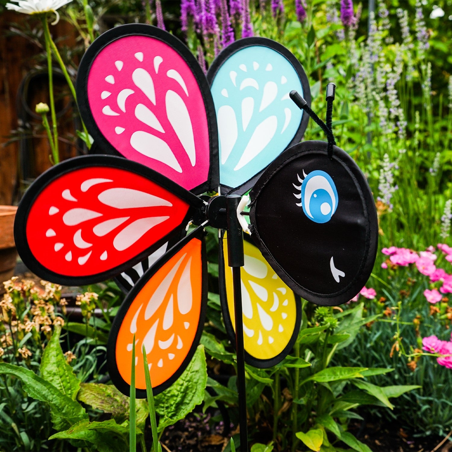 Colorful Butterfly Baby Spinner with baby butterfly design spinning on a garden pole, showcasing bright colors in a sunny outdoor setting.