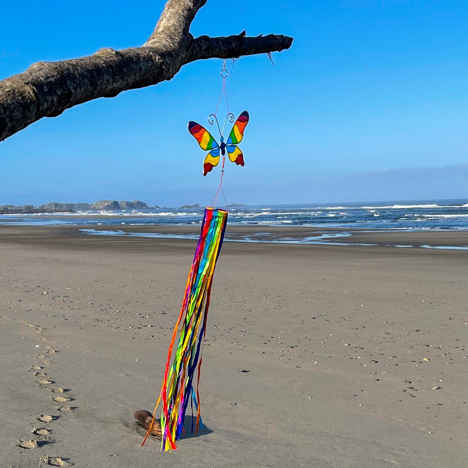 Butterfly & Ribbon Windsock featuring rainbow satin ribbons and a colorful resin butterfly, swaying gently in an outdoor setting.