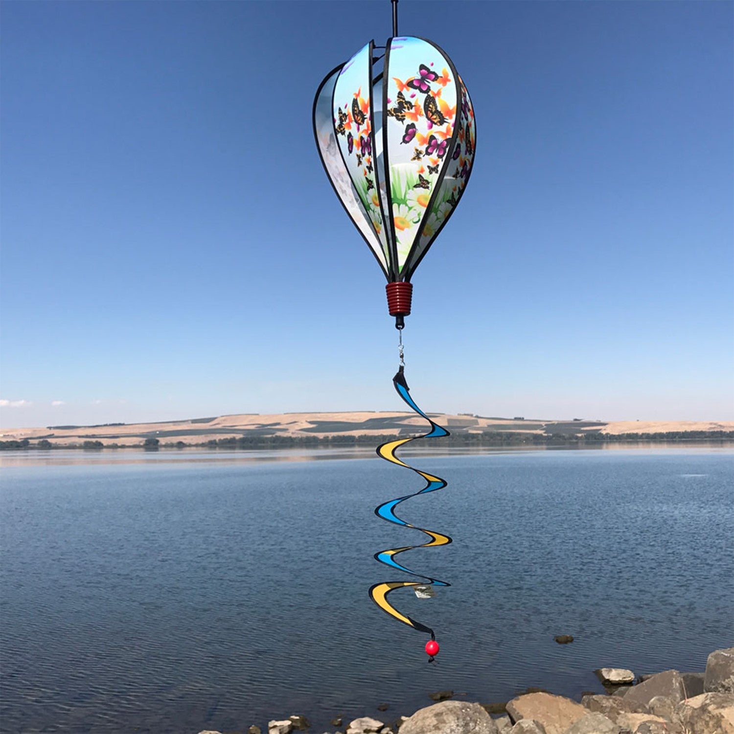 Butterfly Swarm Hot Air Balloon spinning in a garden, featuring colorful butterfly graphics and clear plastic mount for stability.