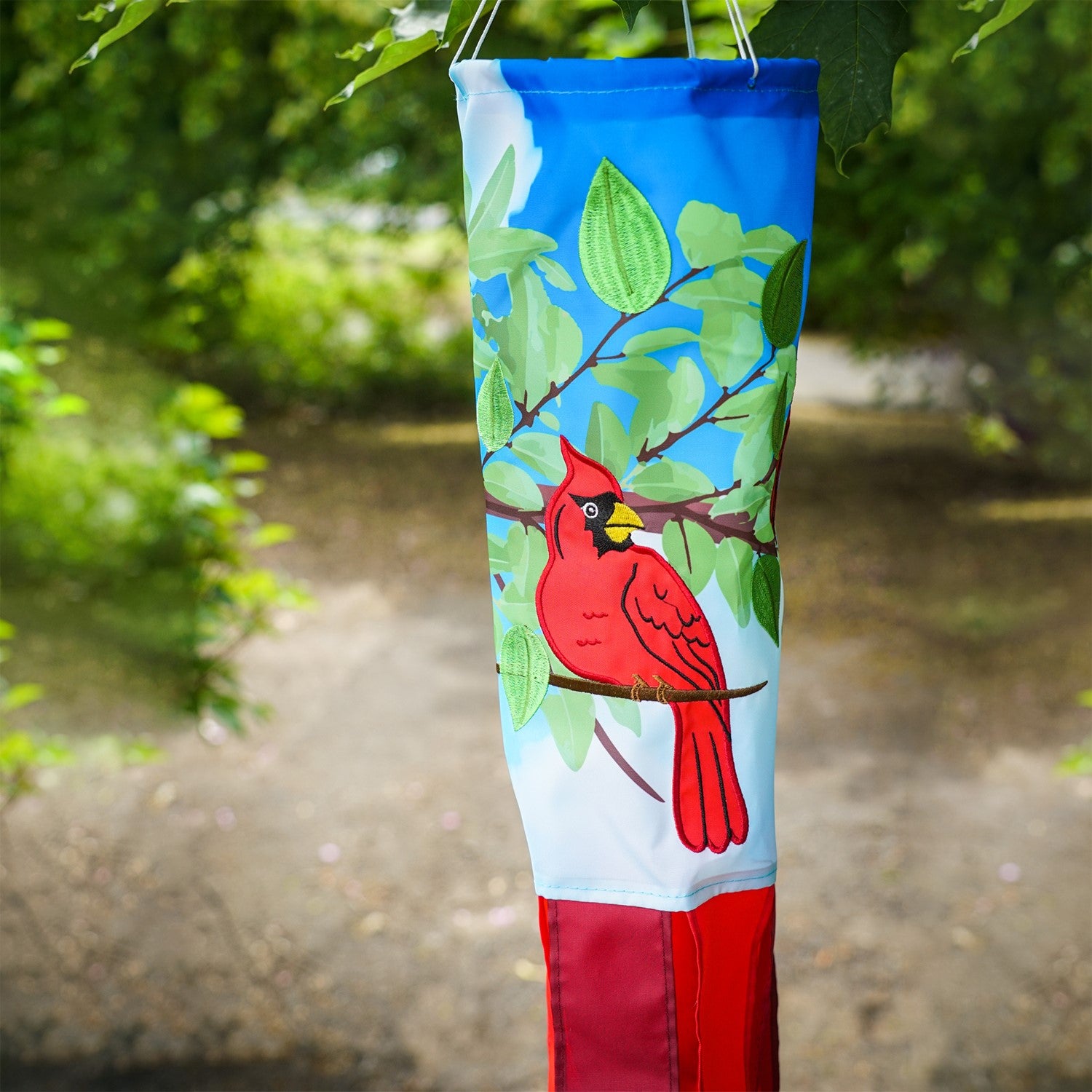 Cardinal 40" Inspiration Windsock with vibrant detail, featuring a red cardinal design and color-coordinated tails, hung as an outdoor decoration.