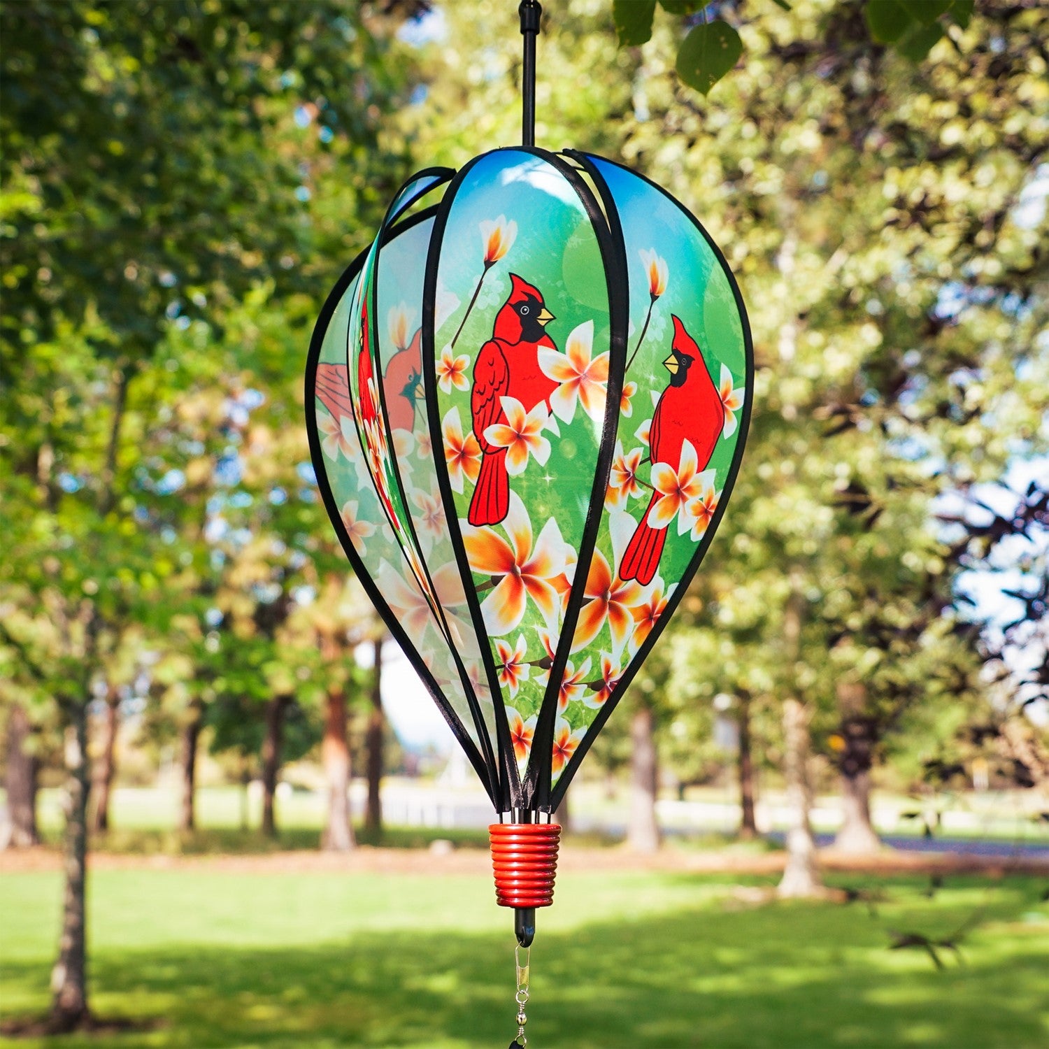 Vibrant Cardinal Hot Air Balloon spinner with cardinal and plumeria design, spinning gracefully in a garden setting to showcase its colorful features.