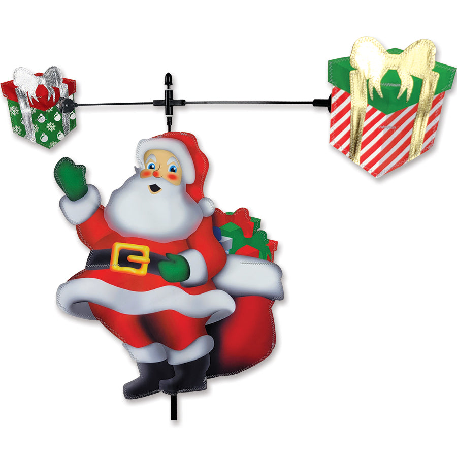 Carousel Spinner - Santa featuring a festive Santa design spinning gracefully in the wind in an outdoor garden setting.