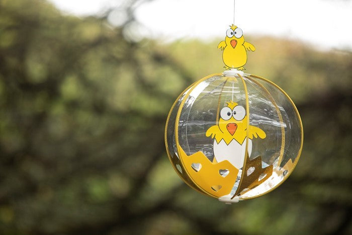 Chicks Spinning Globe wind fairy ornament with colorful baby chicks, spinning gracefully in a sunny outdoor setting.