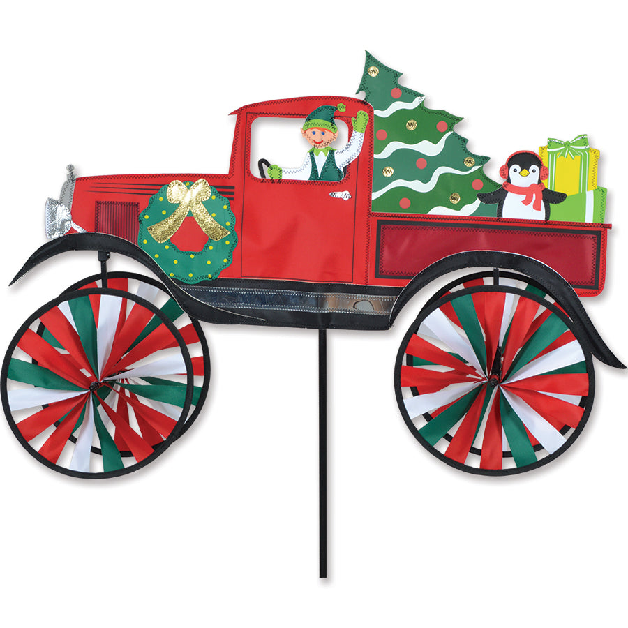 Christmas Truck Spinner featuring a red truck carrying a Christmas tree, spinning joyfully in a winter outdoor setting.