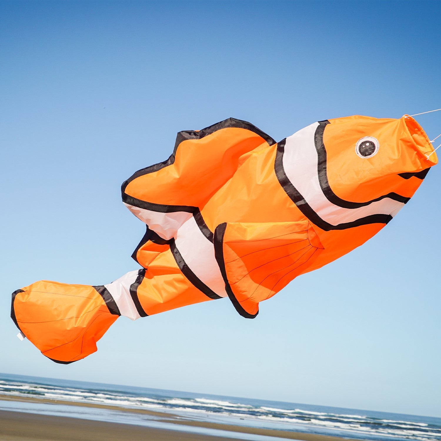 Clownfish Big Breeze WindsockTM, a vibrant 3D windsock with a detailed clownfish design, displayed in a garden setting swaying in the breeze.
