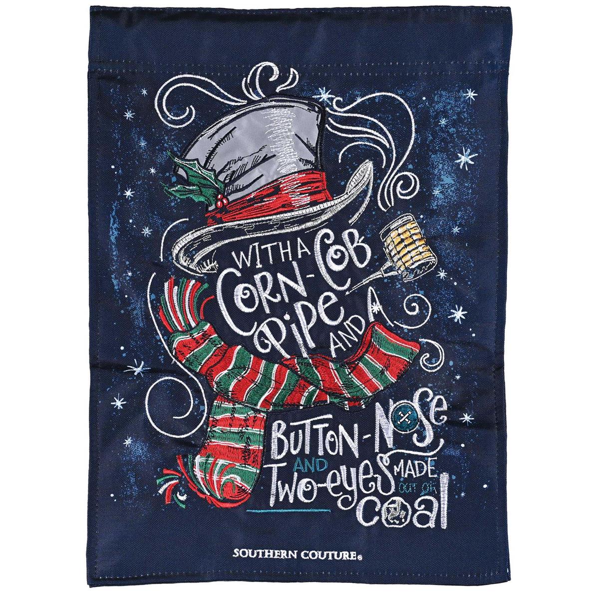 Corn Cob Pipe Snowman garden flag featuring a whimsical snowman design displayed outdoors with snowflakes in a winter garden setting.