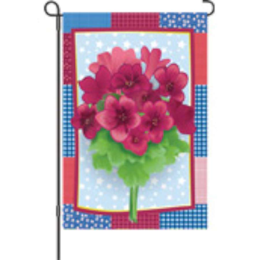 Vibrant 12 in. Country Geraniums garden flag displaying colorful floral graphics, fluttering gently in garden setting with a clear blue sky backdrop.