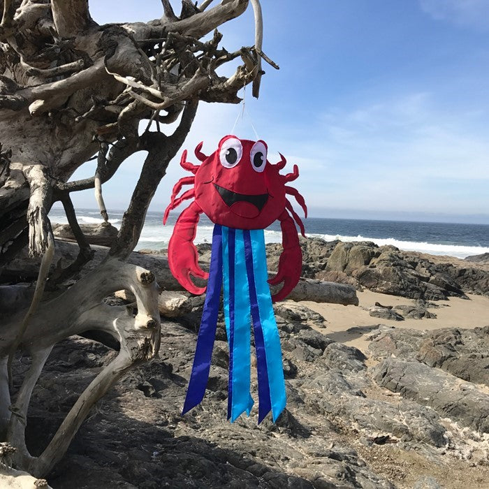 A vibrant red crab windtail with fluttering tails, designed for outdoor decor, showcasing bright 2D graphics hanging from a garden hook.