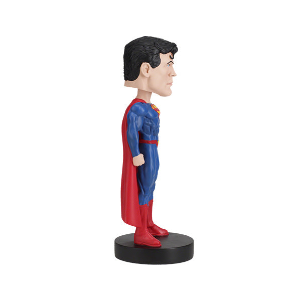 DC Comics Superman 6-inch bobblehead featuring Superman in his Rebirth suit with a vibrant red cape, placed on a display shelf.