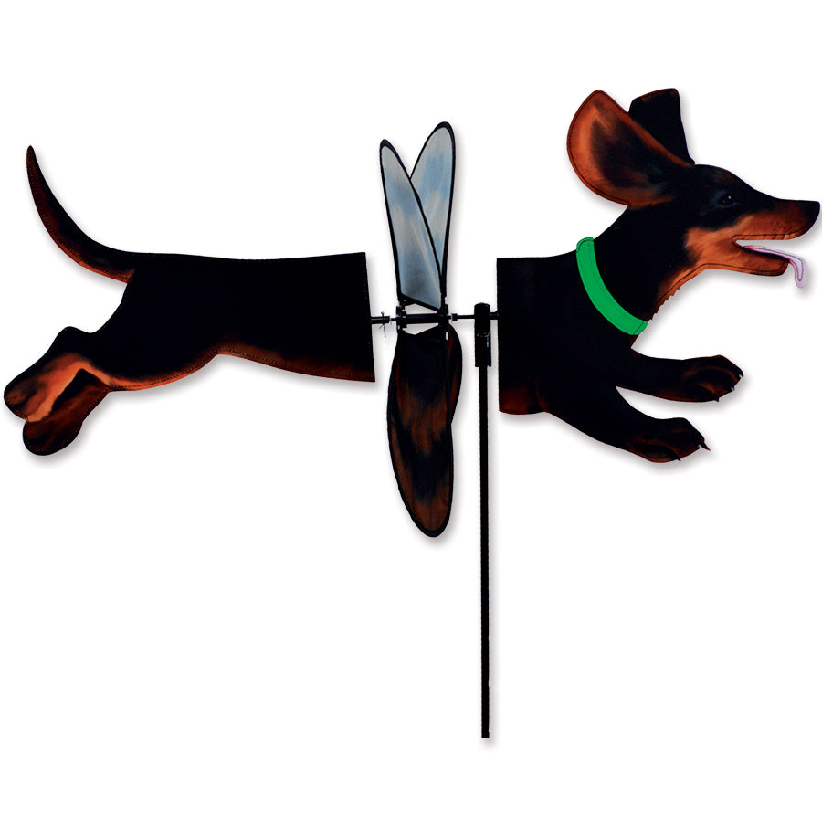 Deluxe Petite Spinner featuring a black and tan dachshund design spinning in a garden setting, showcasing its vibrant colors and gentle movement.